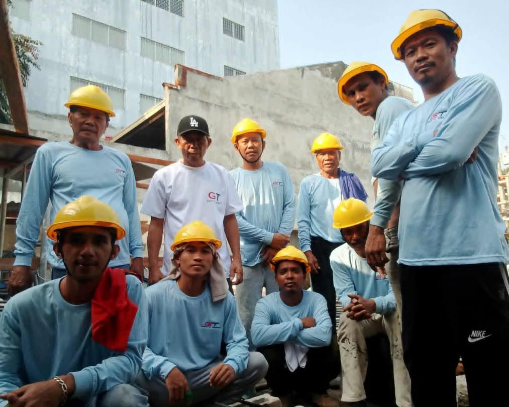GT field crew in yellow hard hats and light blue work shirts on a construction site