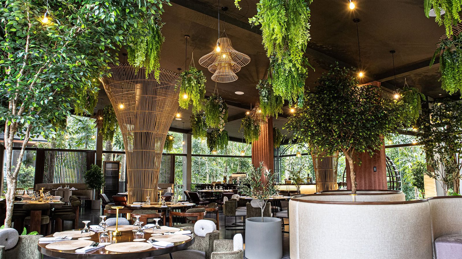 Restaurant interior with hanging plants and woven bamboo columns