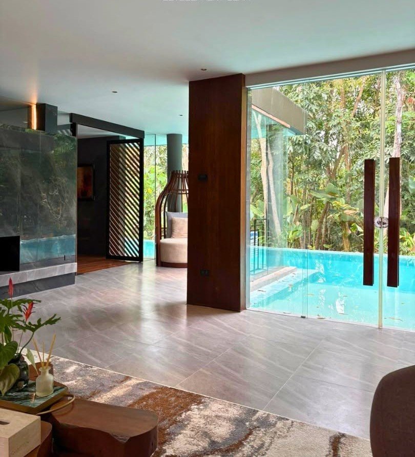 Interior with floor-to-ceiling glass looking out to forest greenery